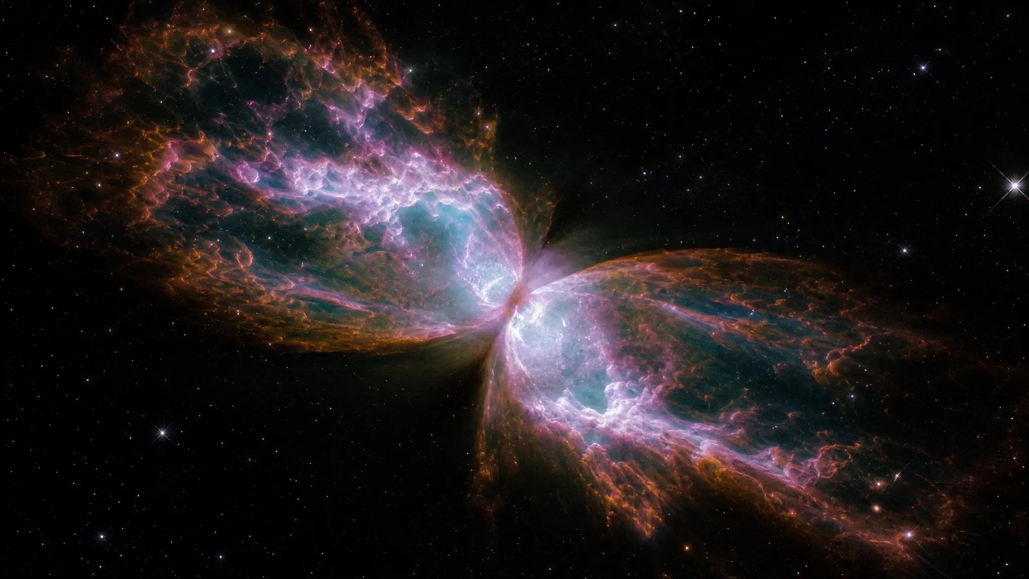 A butterfly-shaped planetary nebula with iridescent pink, orange, and cyan gas c